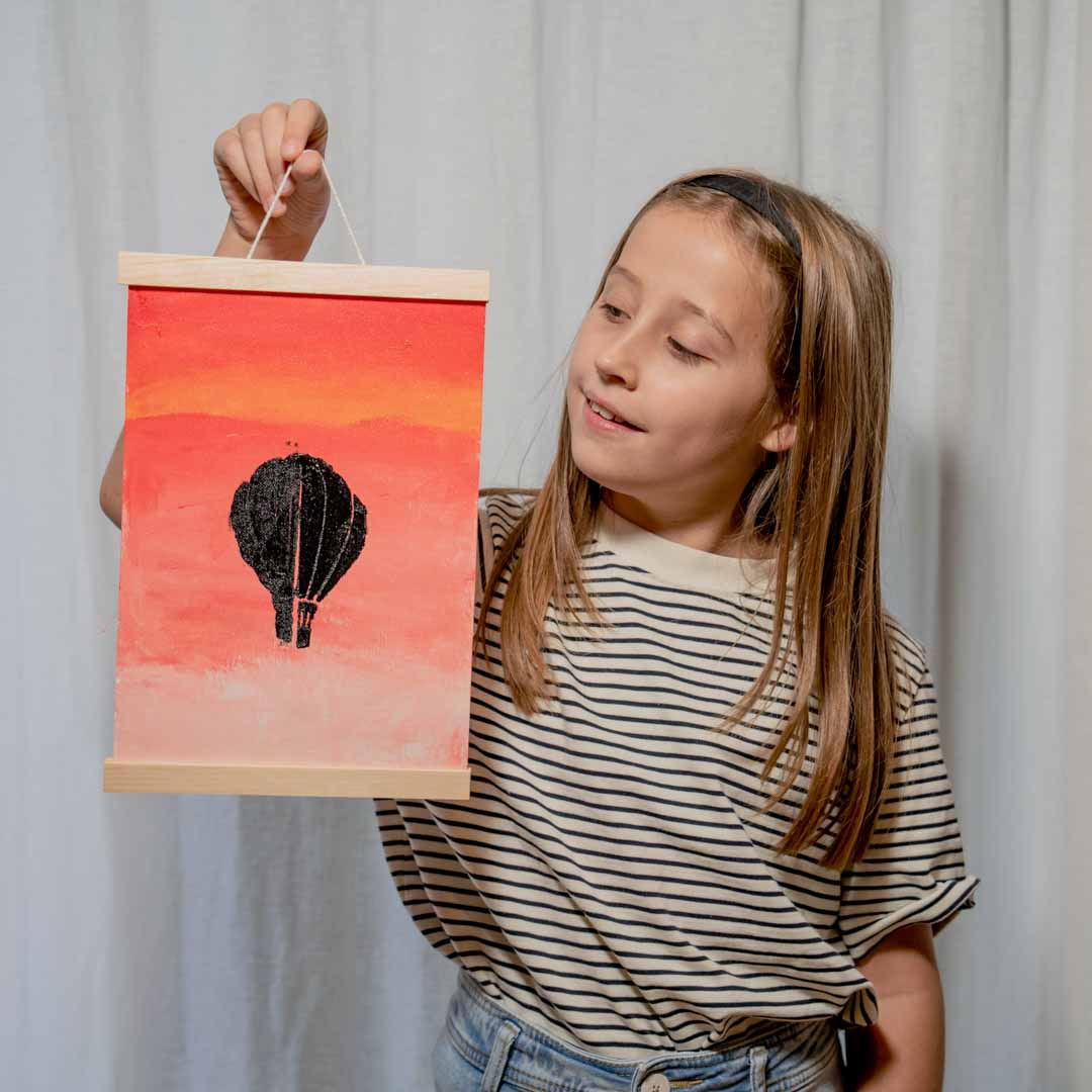 Girl holding her finished Sculpd canvas painting in front of her