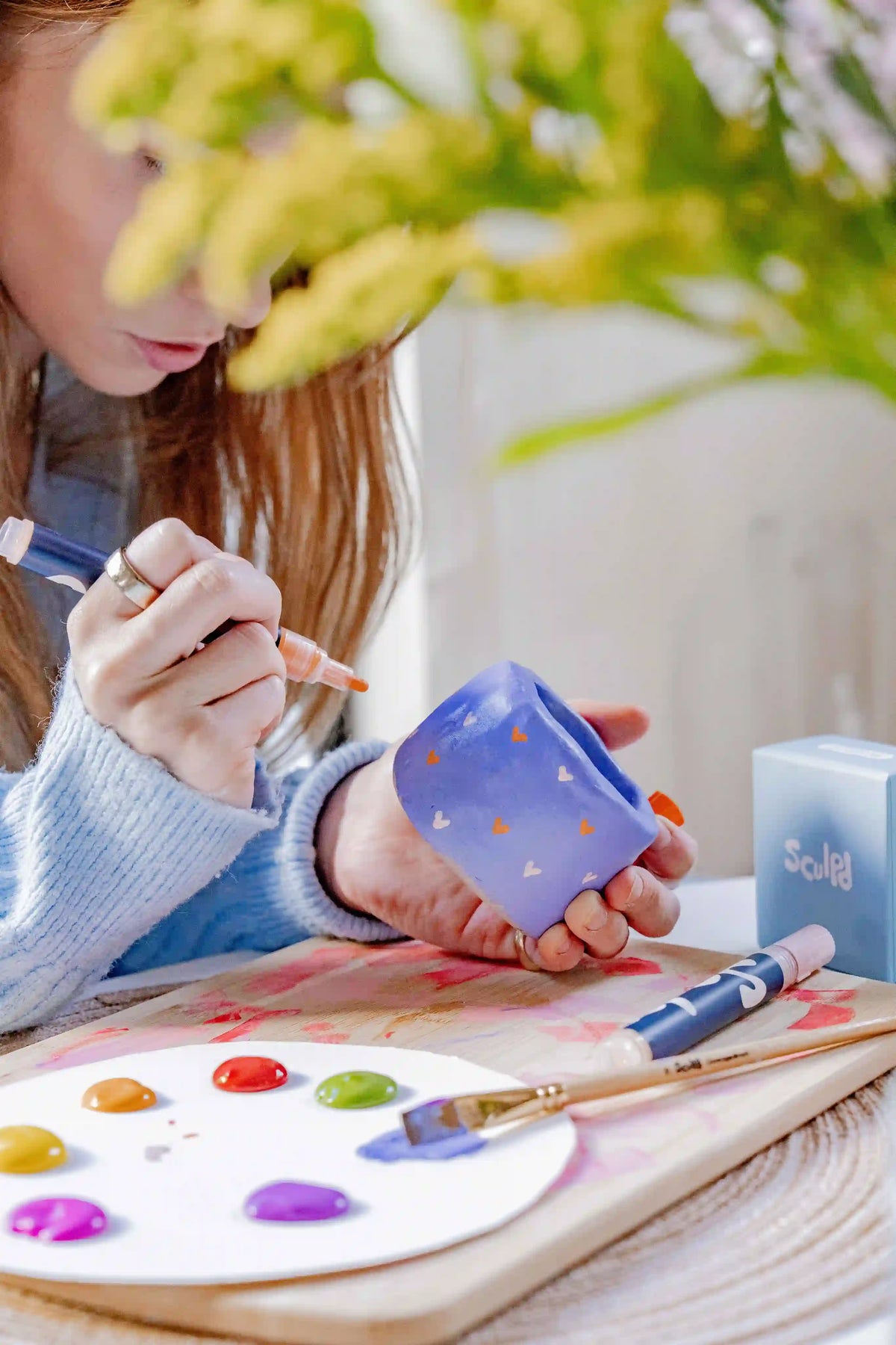Artist painting a ceramic mug
