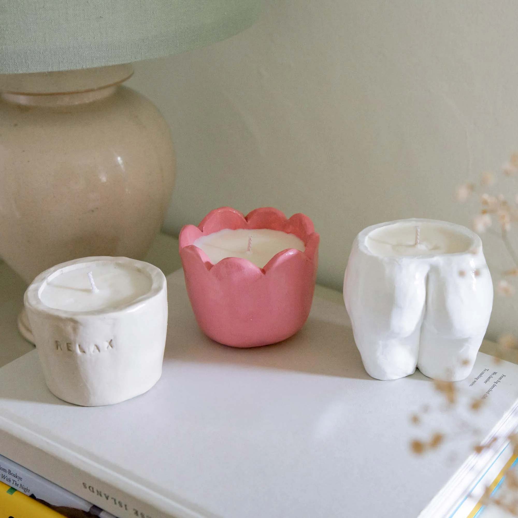 Three Sculpd Candle Making Kit pots laid out on a table with stylized decor
